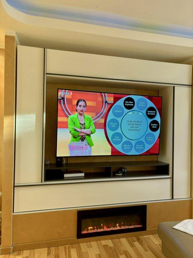 Detailansicht des modernen TV-Möbels mit integriertem elektrischem Kamin im Wohnzimmer.