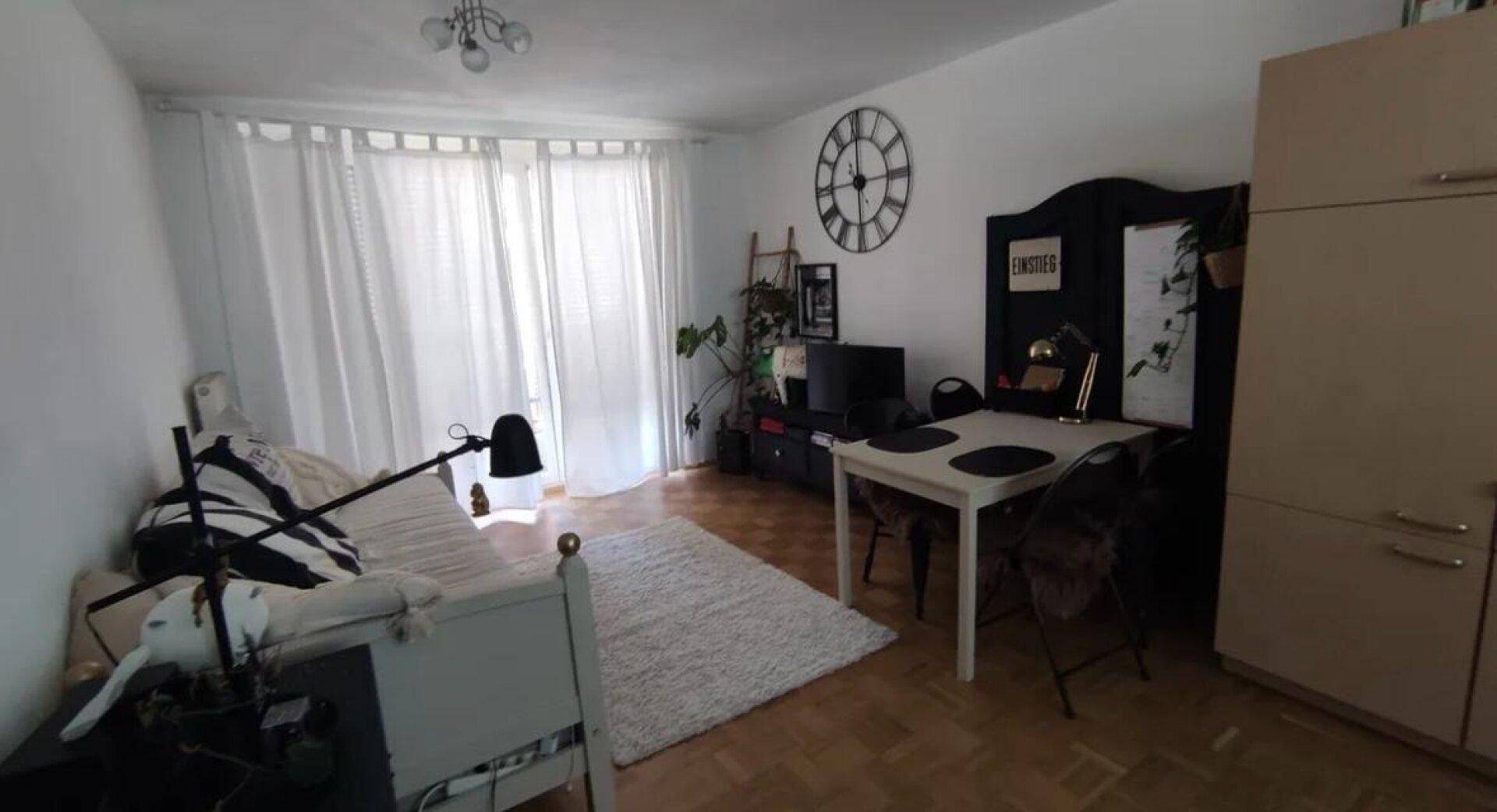 Heller Wohn- und Essbereich mit Parkettboden, Esstisch und Zugang zum Balkon.