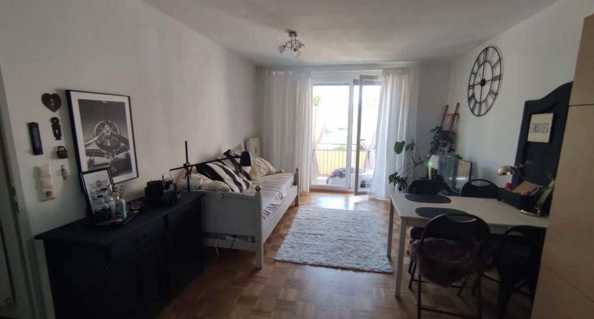 Geräumiger Wohn- und Essbereich mit Tagesbett, Esstisch und Zugang zu einem Außenbereich.
