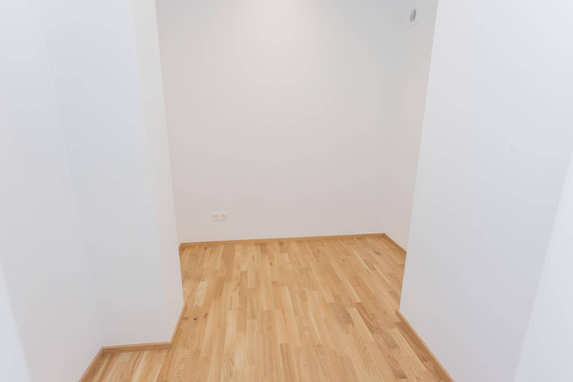 Kleiner Durchgangsbereich mit hellem Parkettboden und weißen Wänden.