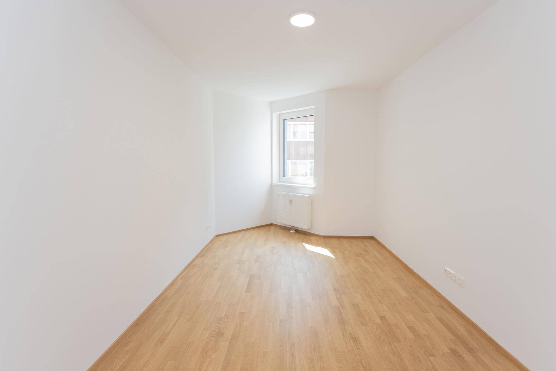 Helles Zimmer mit Parkettboden und Fenster, bereit zur individuellen Gestaltung, frisch renoviert.