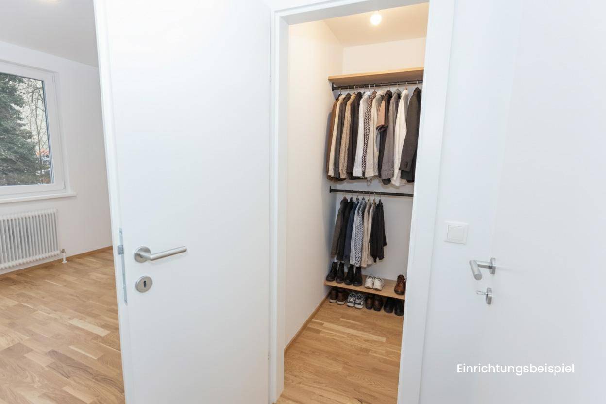 Heller Raum mit Parkettboden und offenem Zugang zu einem begehbaren Kleiderschrank.