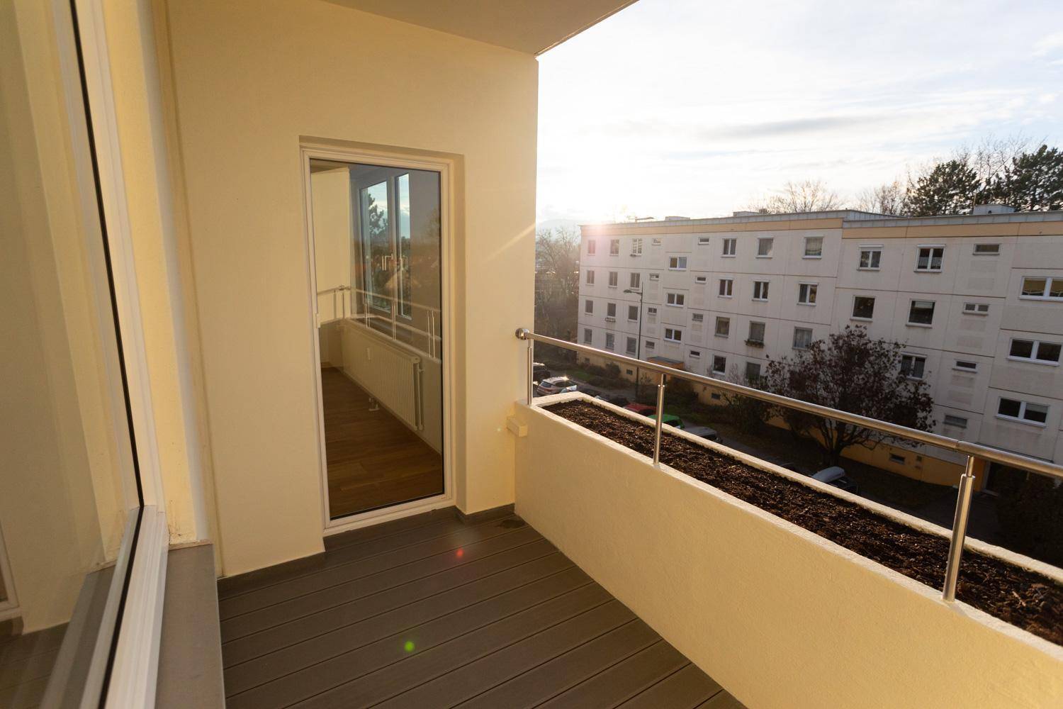 Geräumiger Balkon mit Blick auf die umliegenden Gebäude und grüne Bäume.