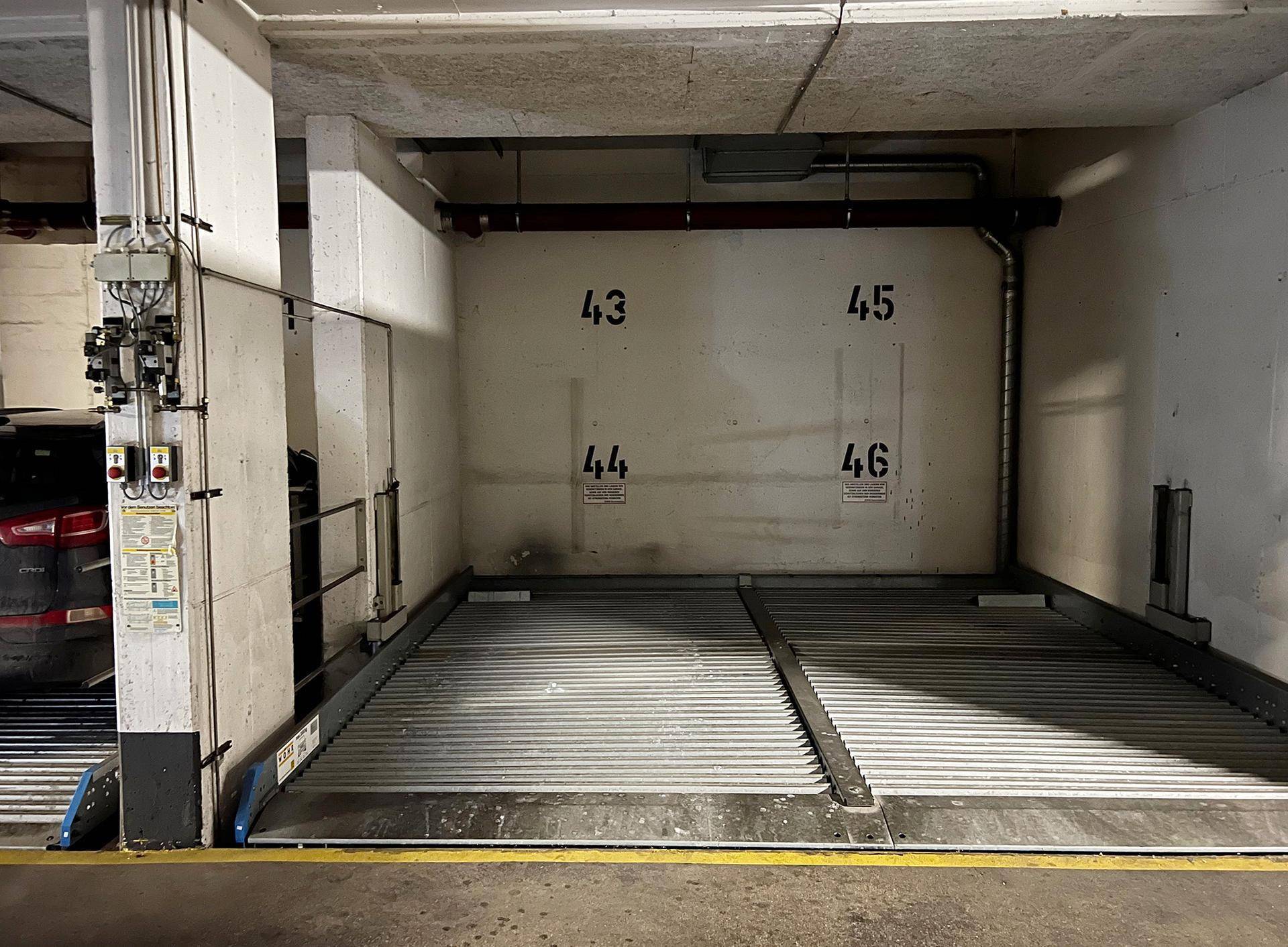 Tiefgarage mit zwei Parkplätzen auf Hebebühnen, bietet sichere Stellmöglichkeiten.