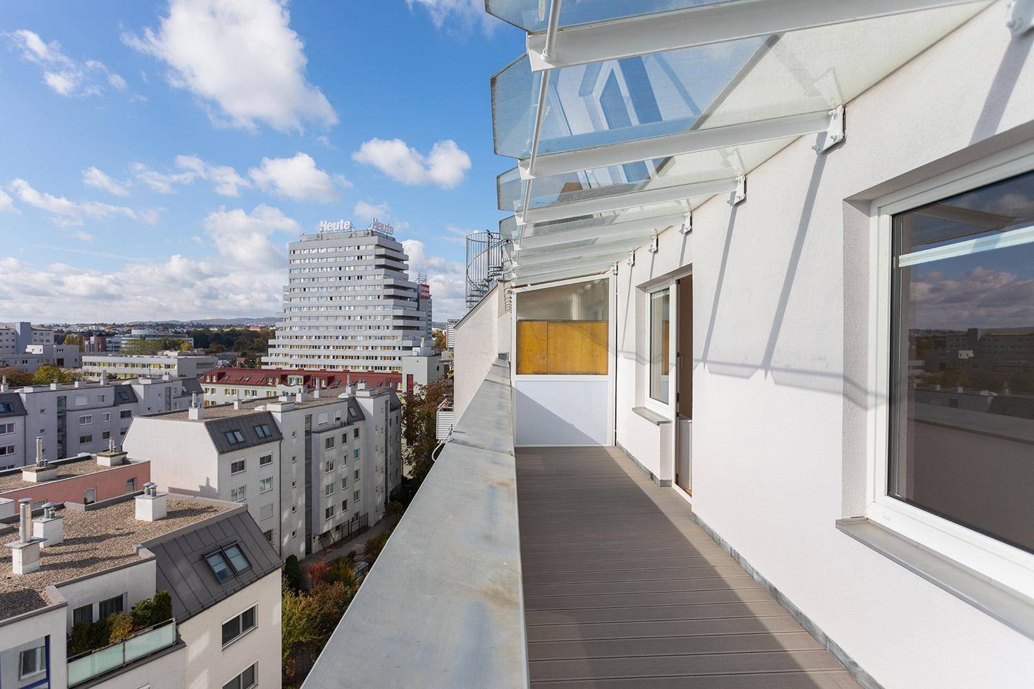 Moderne Loggia mit Glasüberdachung und Panoramablick über die städtische Umgebung.