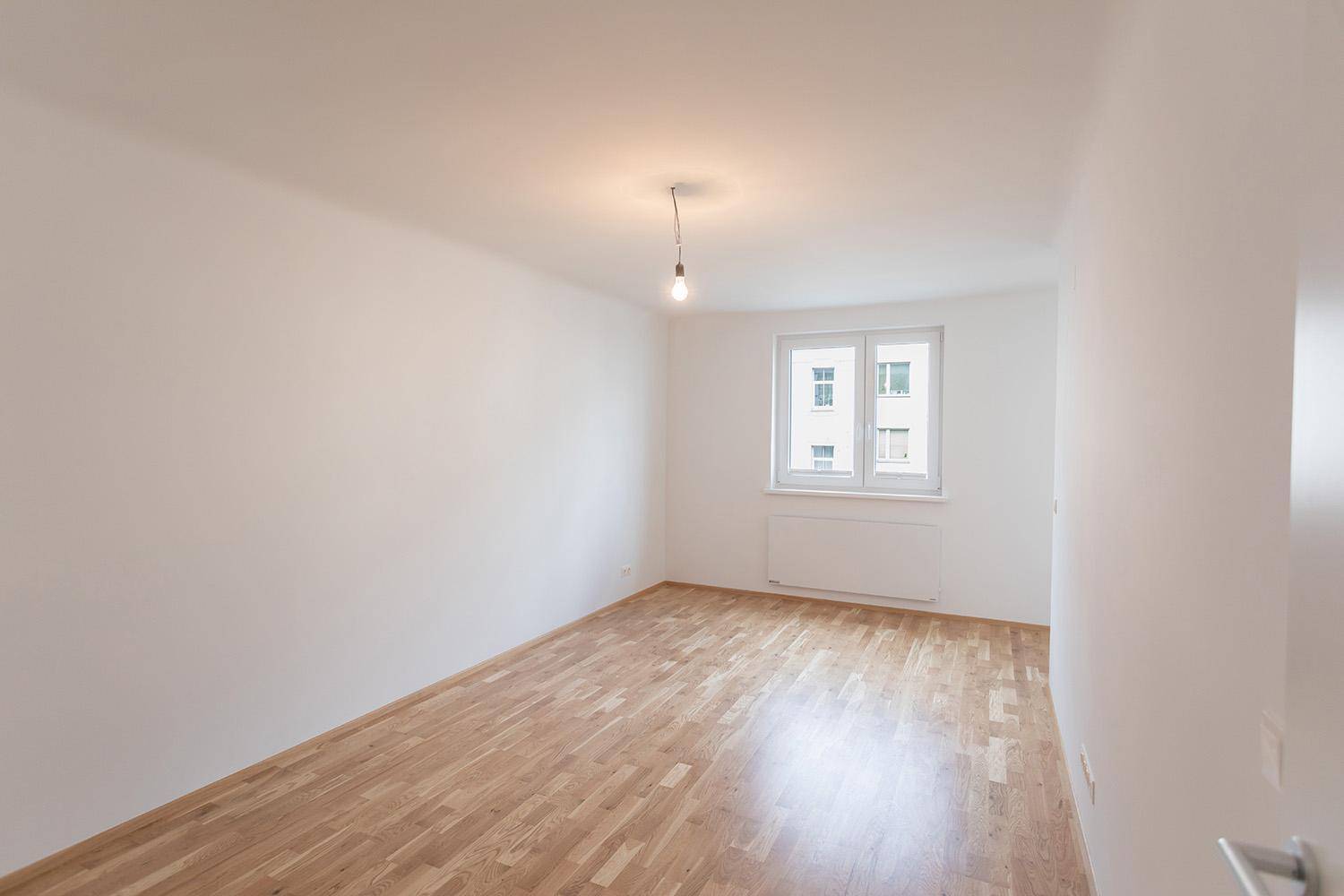 Helles Zimmer mit Parkettboden und Fenster, unmöbliert und bezugsfertig, vielseitig nutzbar.
