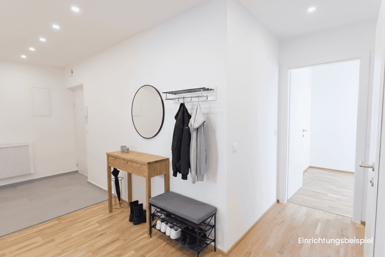 Heller Flur mit Garderobe, Spiegel und Holzparkettboden, als Einrichtungsbeispiel.