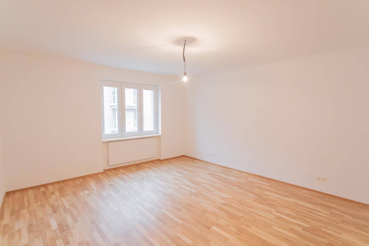 Geräumiges, helles Zimmer mit Parkettboden und großen Fenstern, vielseitig nutzbar.