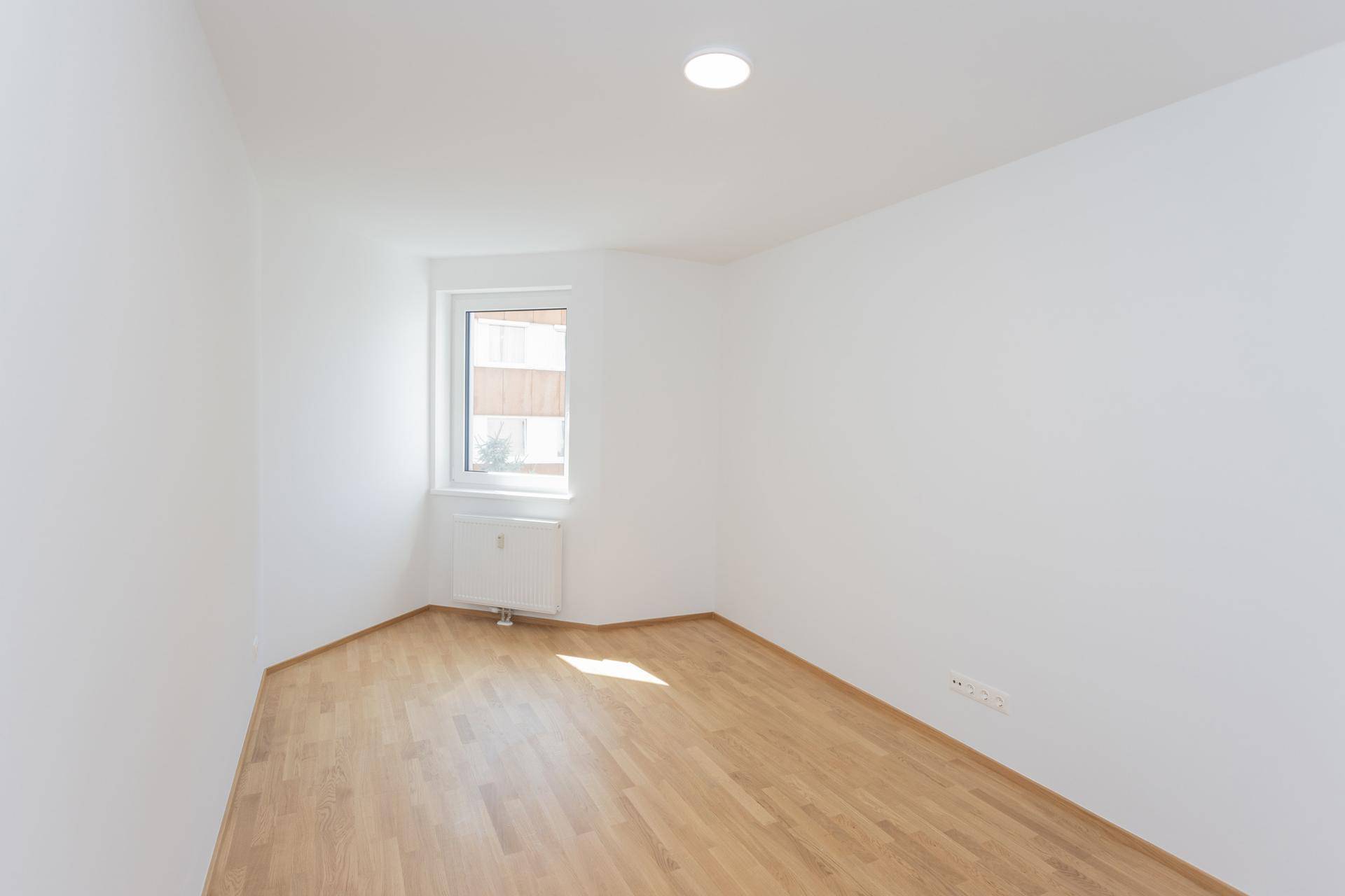 Helles Zimmer mit Parkettboden und Fenster, bereit zur individuellen Gestaltung, frisch renoviert.