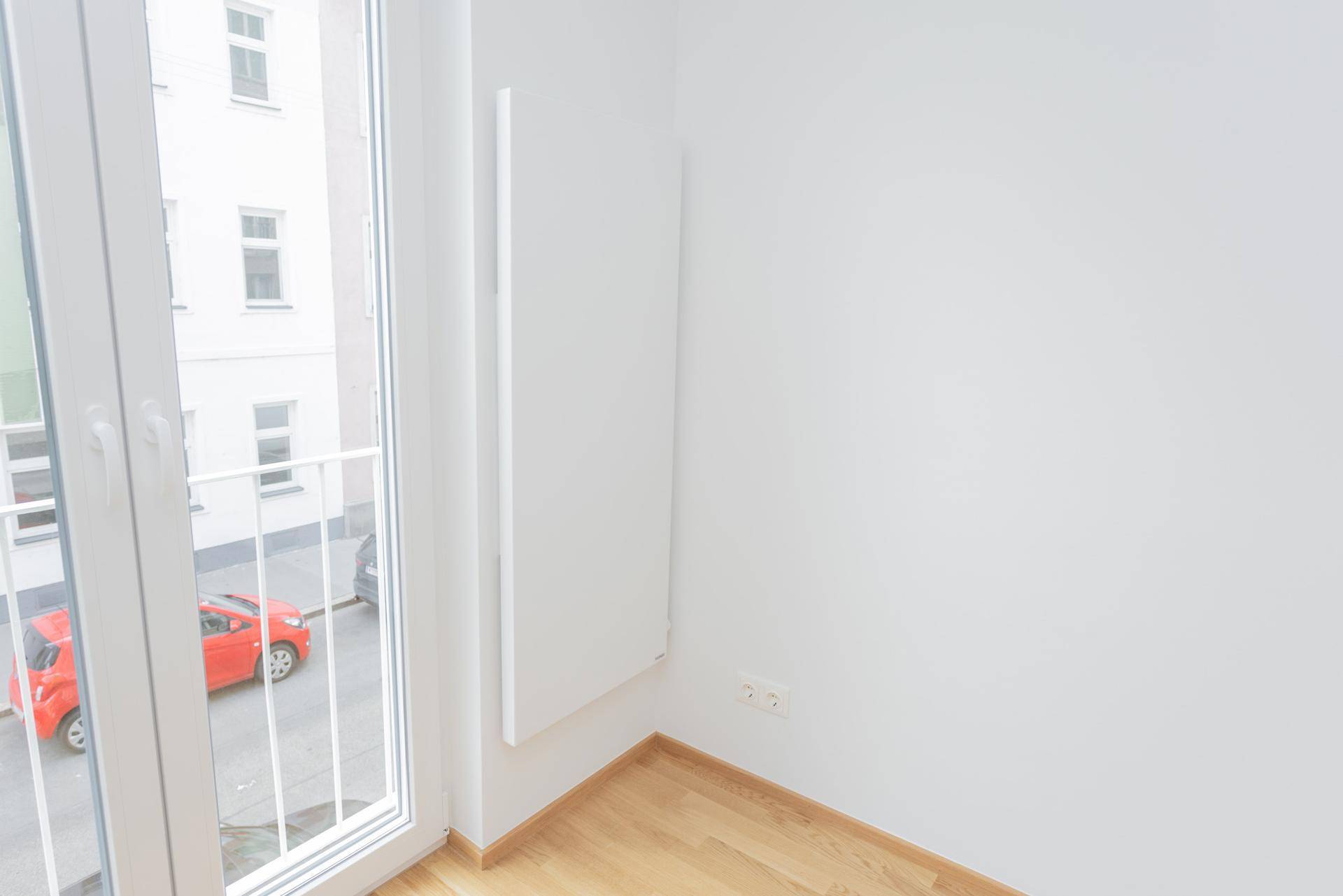 Detailansicht eines französischen Balkons mit Blick auf die Straße und umliegende Gebäude.