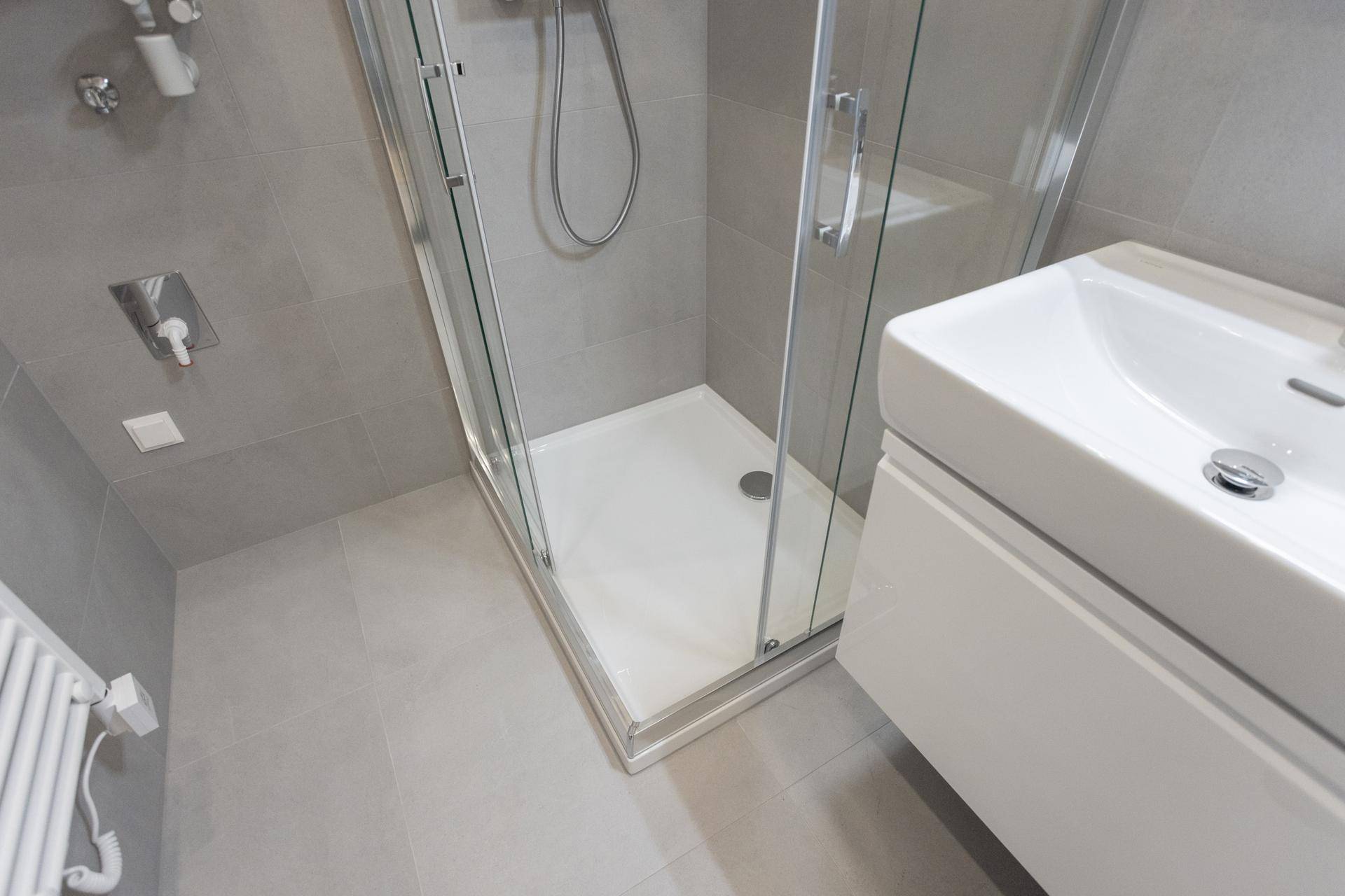 Detailansicht des modernen Badezimmers mit Duschkabine und Waschtisch.