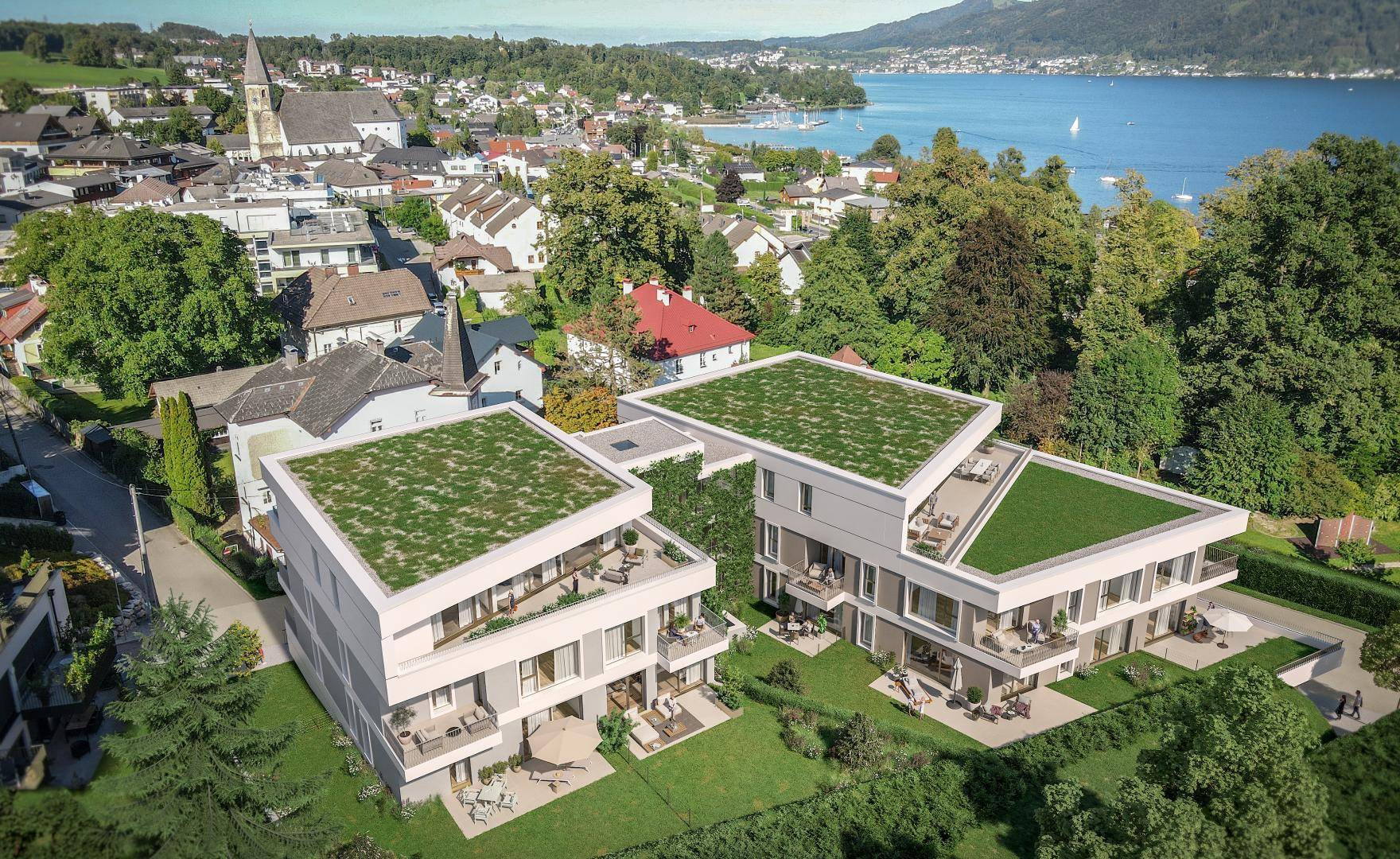 Attraktive Wohngebäude mit begrünten Dächern und Blick auf den See und die Stadt.