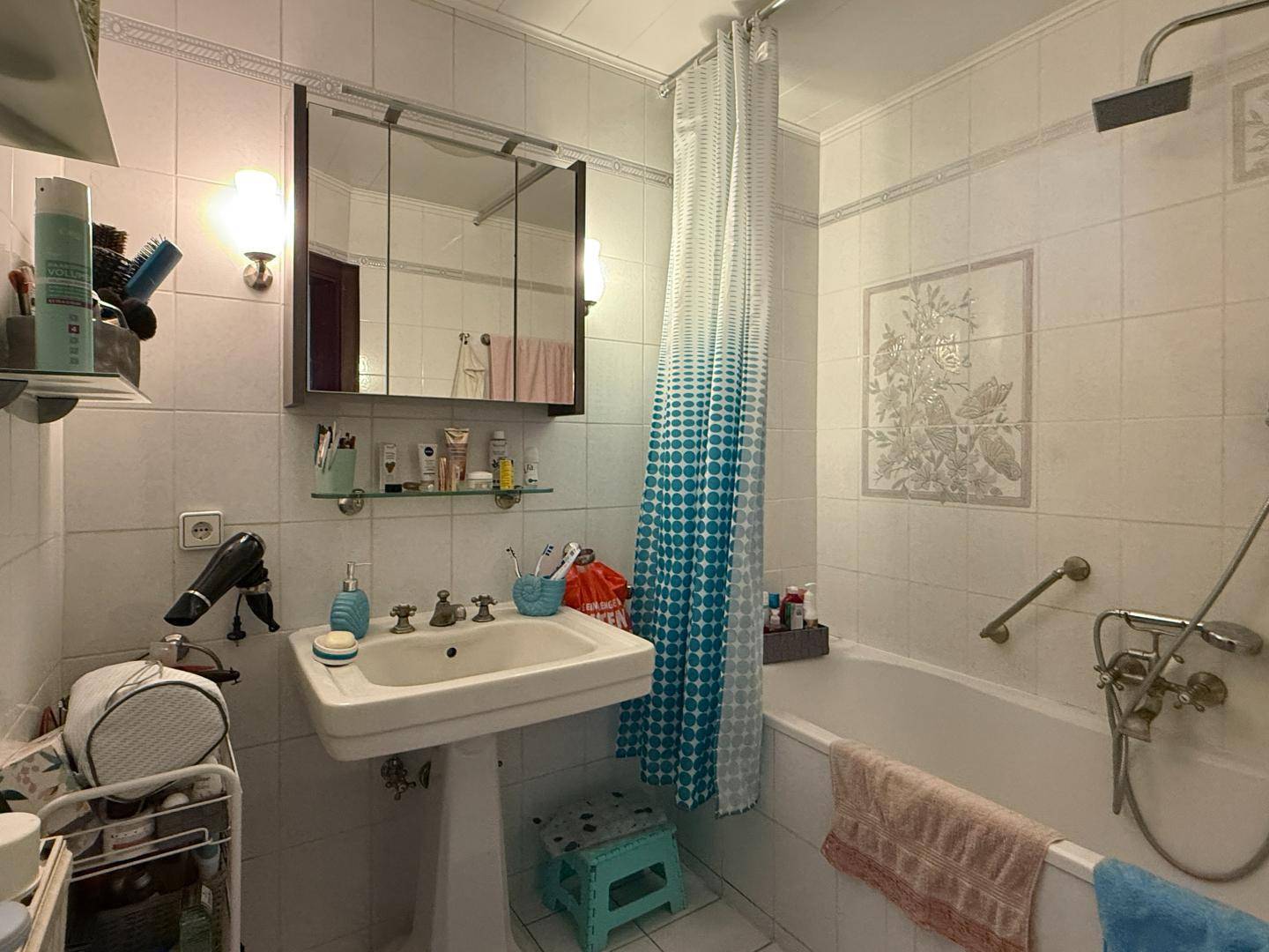 Klassisches Badezimmer mit Badewanne, Waschbecken und Spiegelschrank.