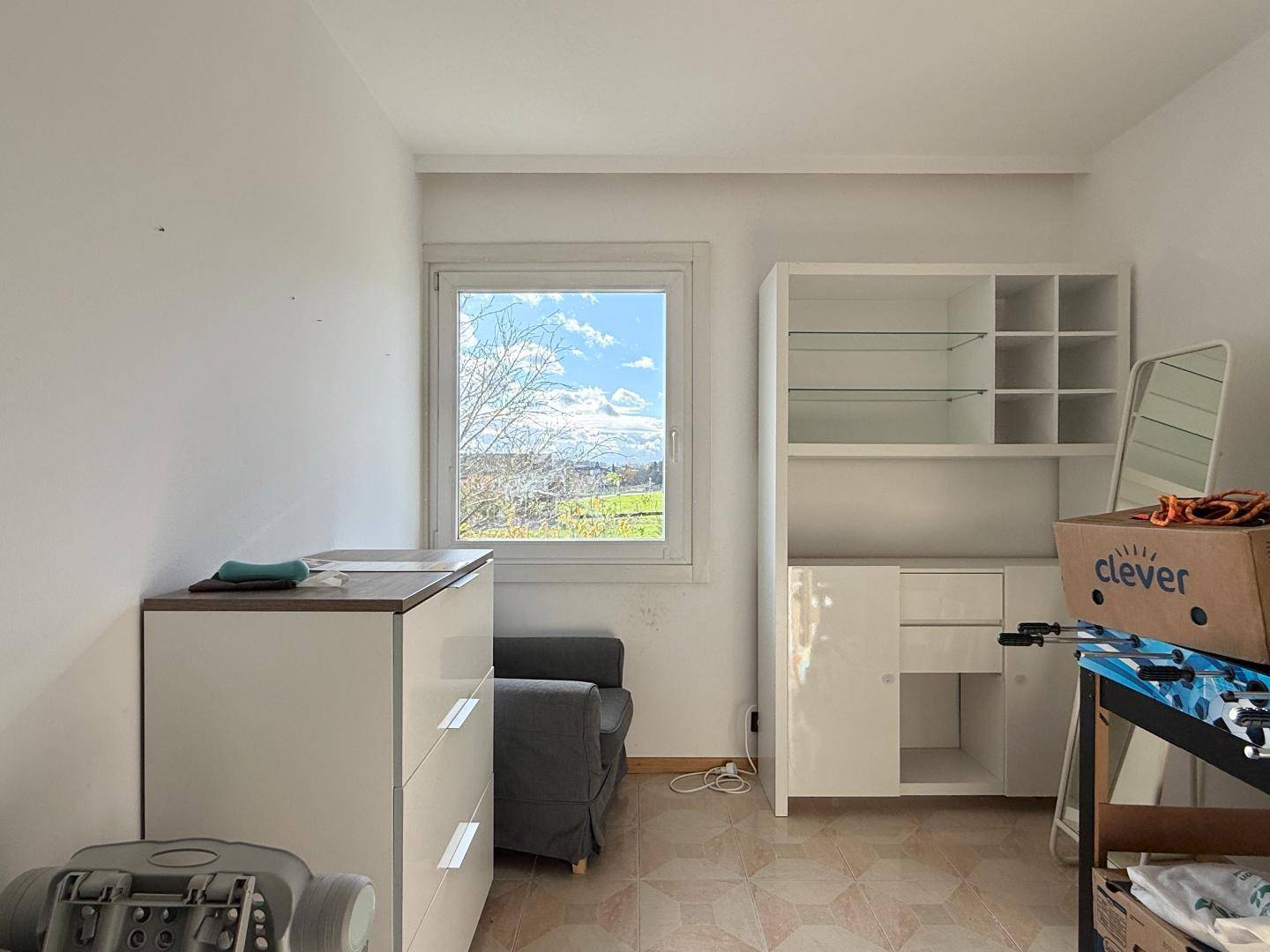 Helles Zimmer mit Stauraum und Fenster mit Blick ins Grüne.