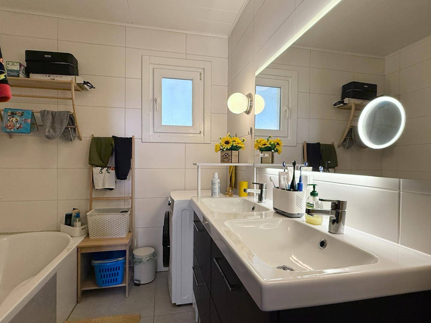 Modernes Badezimmer mit Doppelwaschbecken, Badewanne und großem Spiegel.