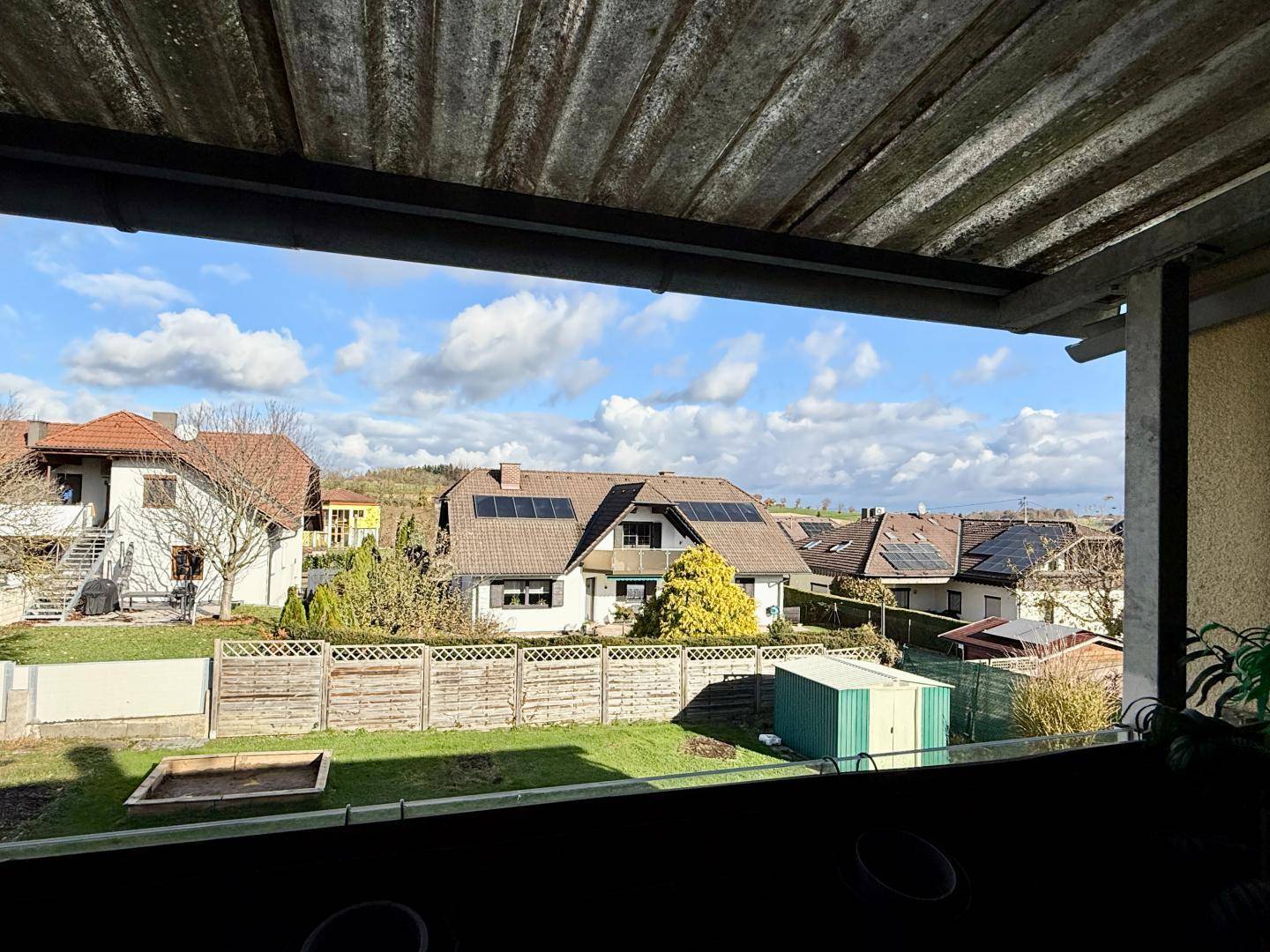 Weitläufiger Blick vom Balkon über den Garten und die umliegende Wohngegend.