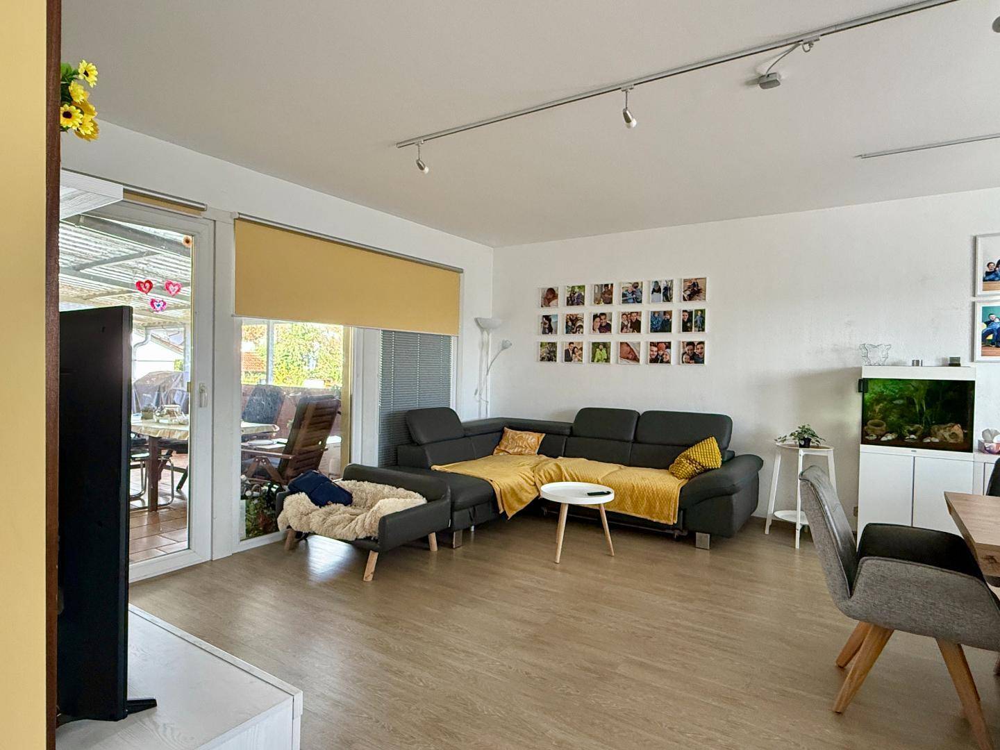 Heller Wohn-Essbereich mit modernem Laminatboden und Zugang zur Terrasse.