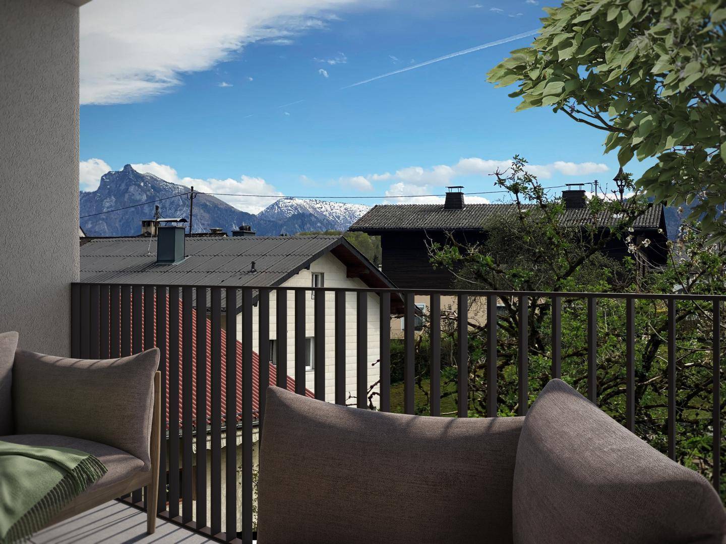 Balkon mit bequemen Kissen und einem weiten Blick über die Dächer der Häuser auf die Berge.