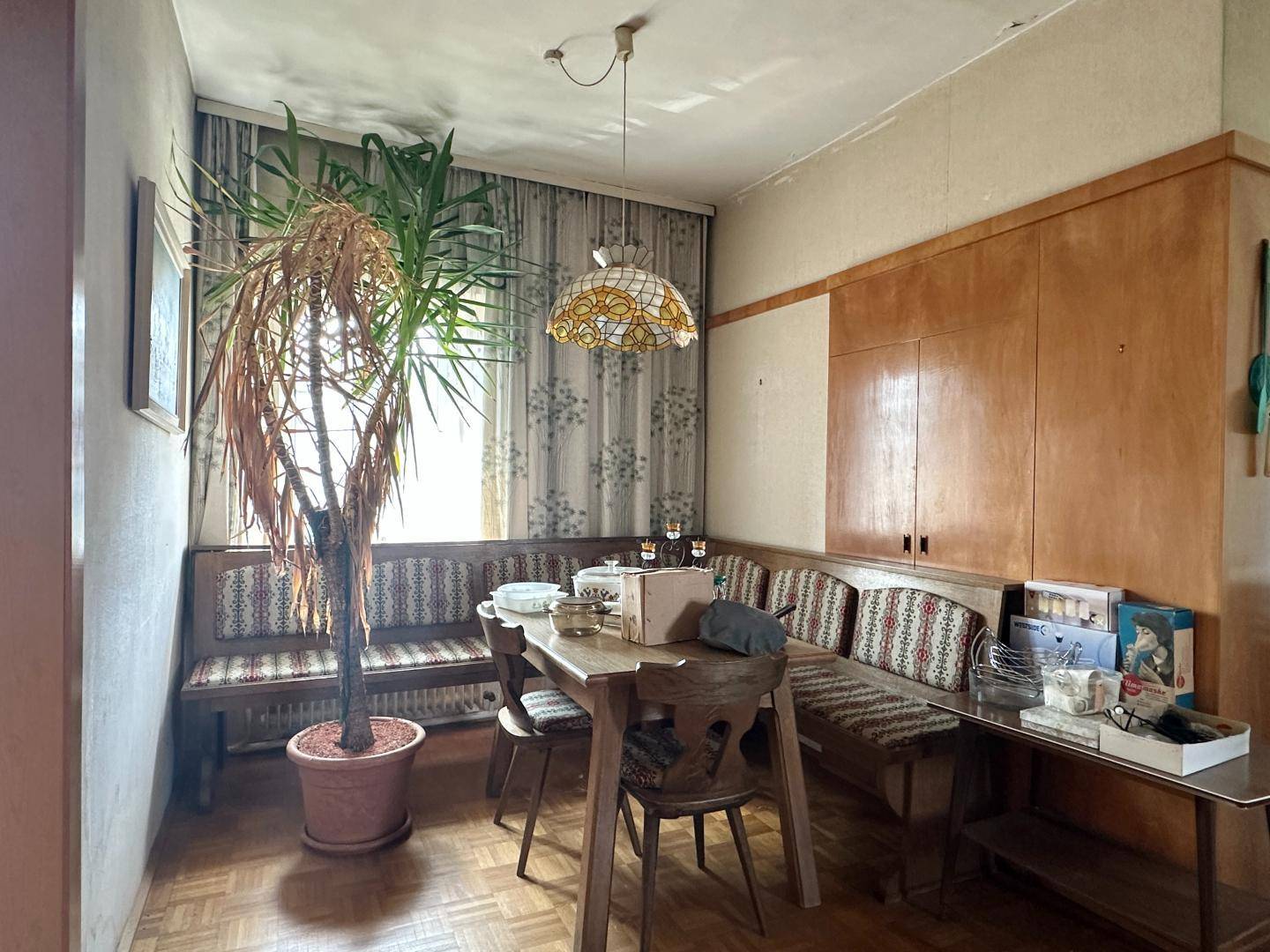 Esszimmer im traditionellen Stil mit Holzbänken, Esstisch und großem Topfbaum.