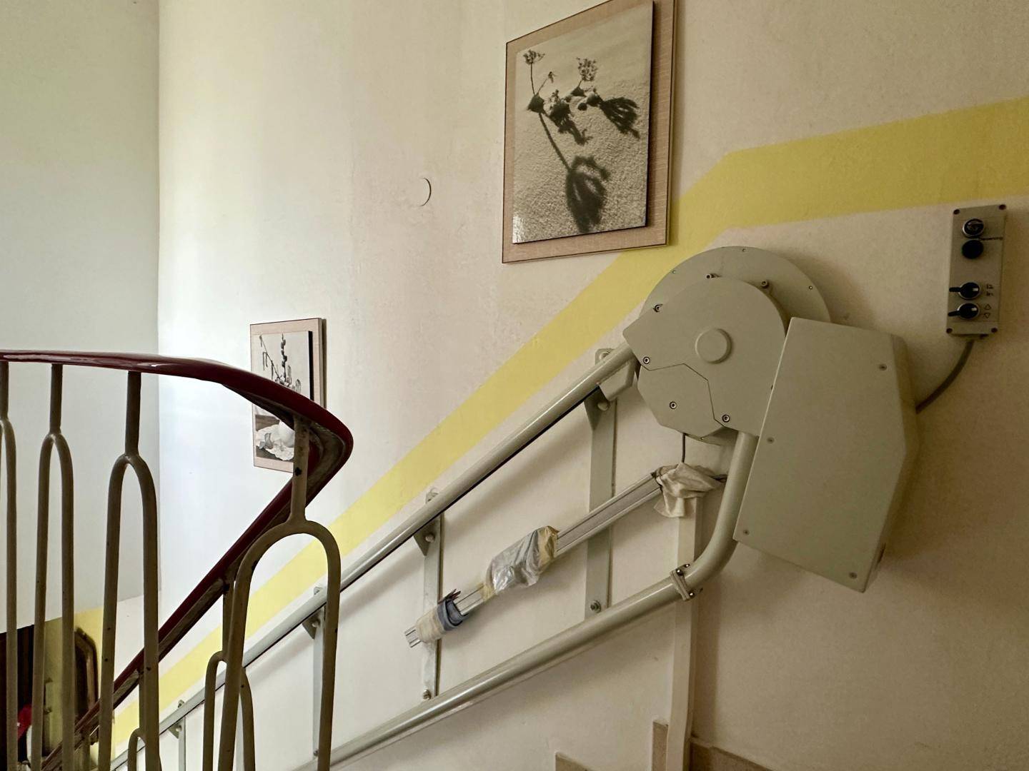 Treppenhaus mit installiertem Treppenlift für barrierefreien Zugang zu den oberen Etagen.