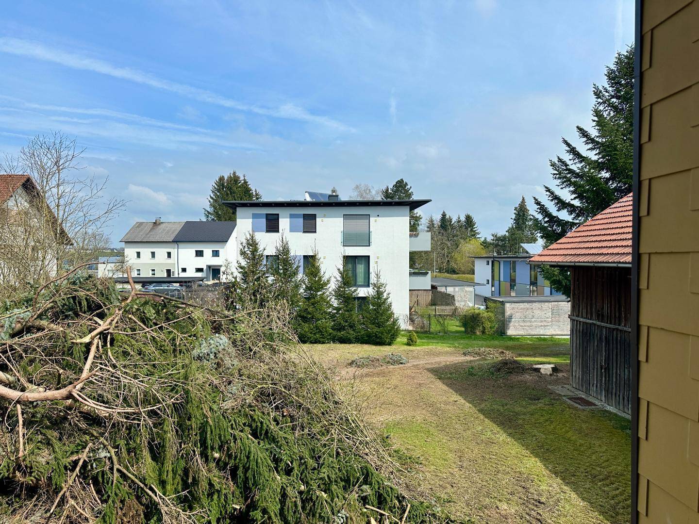 Blick auf umliegende Gebäude und grüne Landschaft unter blauem Himmel.