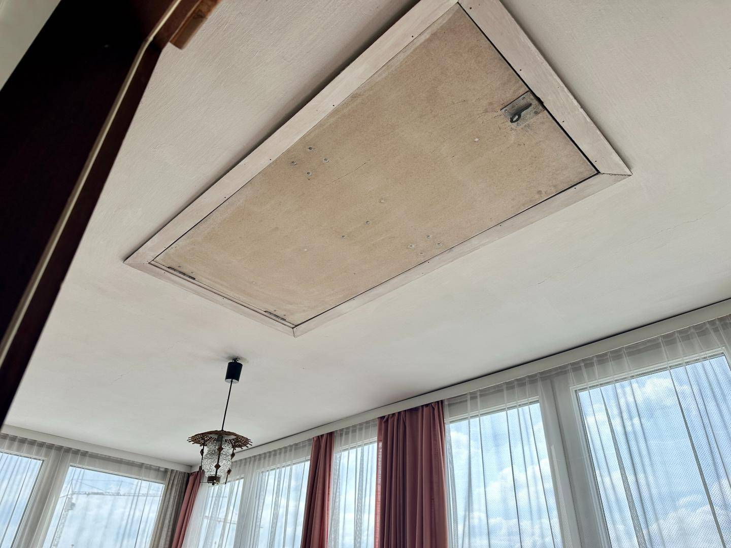 Deckenansicht im verglasten Balkon mit einer Dachluke und Hängelampe.