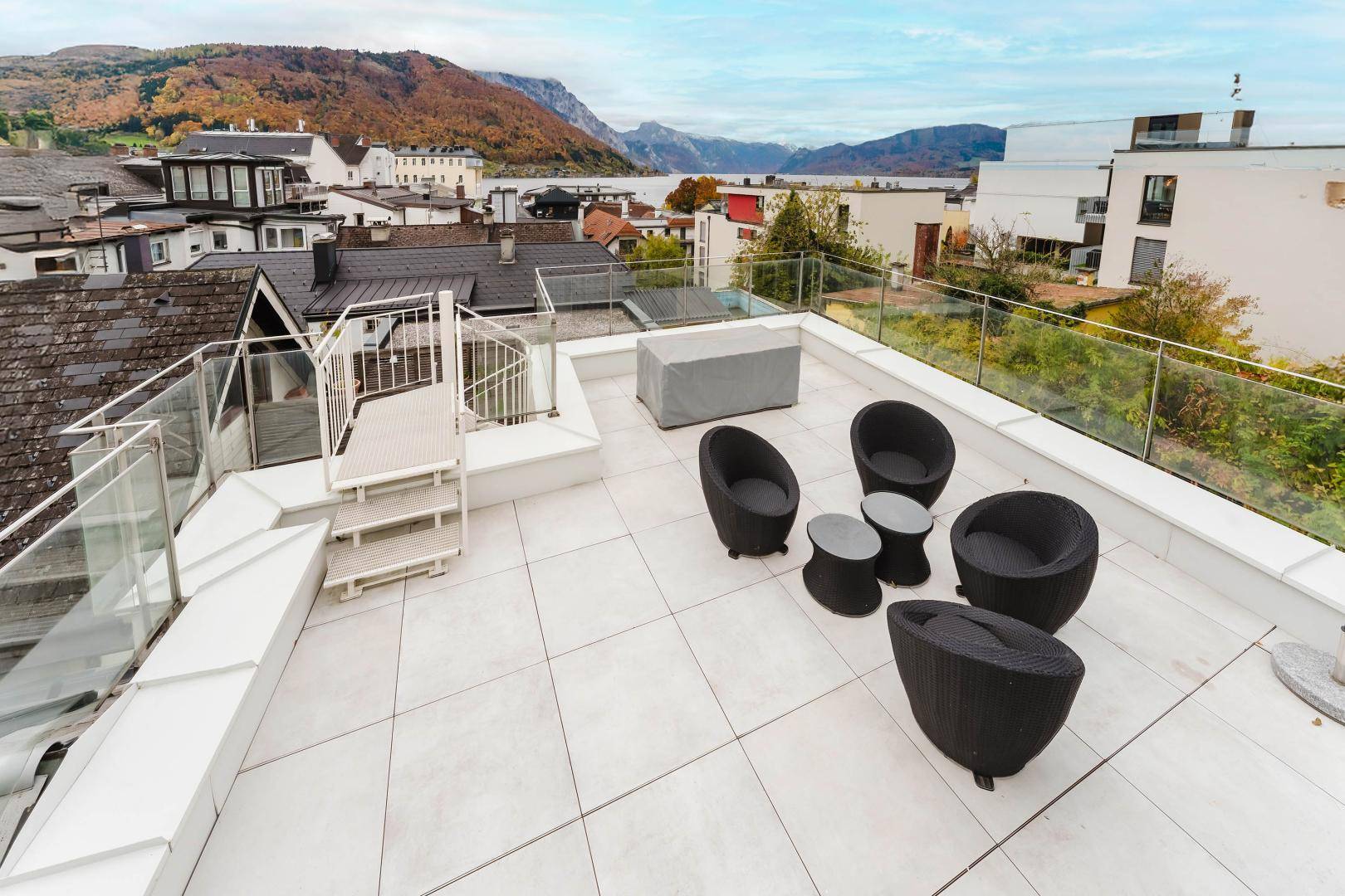 Weitläufige Dachterrasse mit Panoramablick auf die umliegende Landschaft, den See und die Berge.