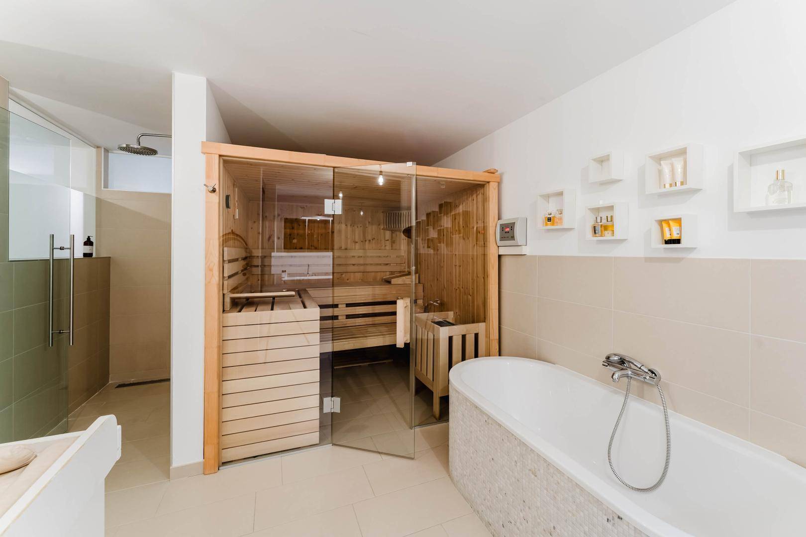 Großes Badezimmer mit Sauna, Badewanne und separater Dusche.