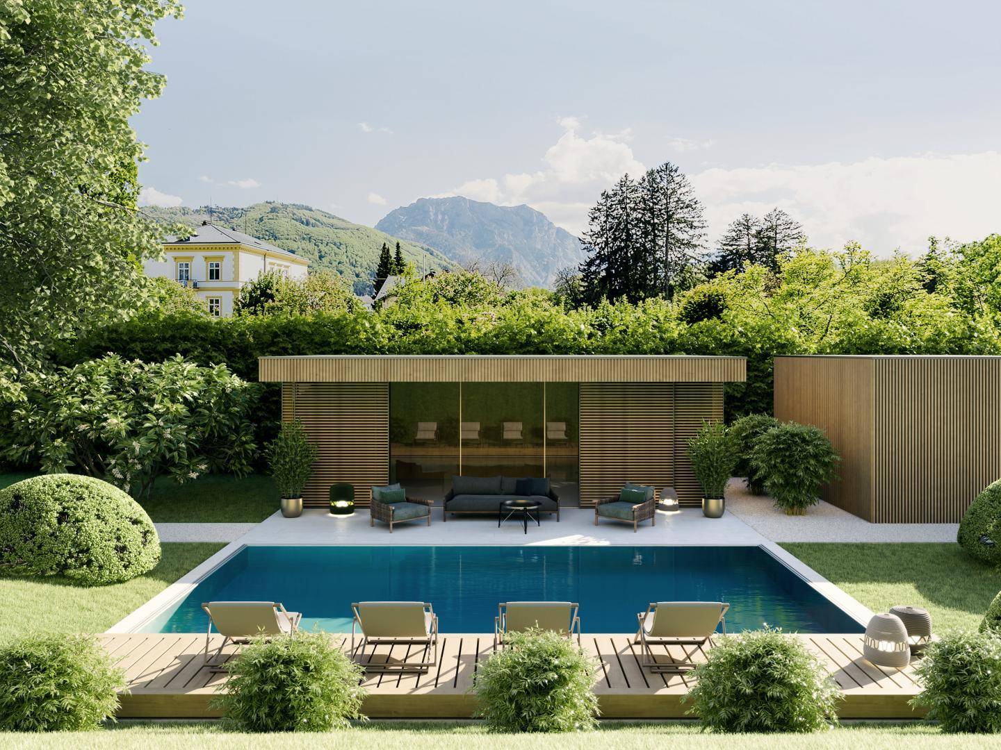 Außenpoolbereich mit Liegestühlen, umgeben von Grünflächen und einem modernen Poolhaus mit Bergblick.