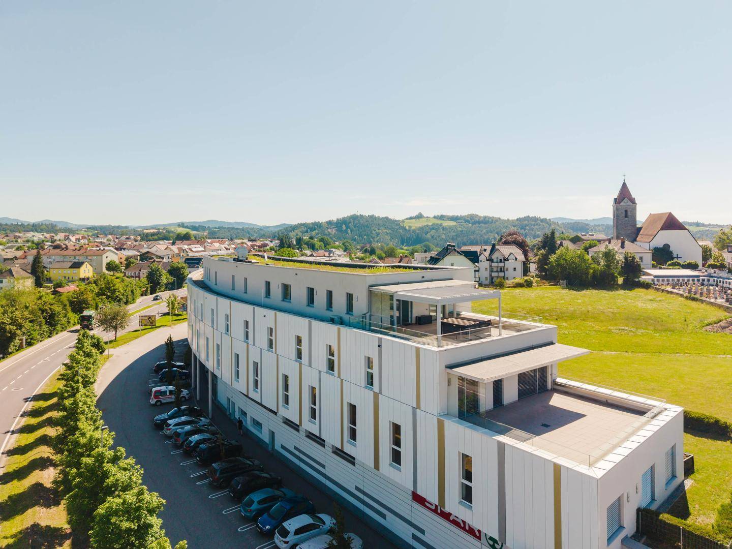 Moderne Architektur des Gebäudes mit Gründach und umliegender ländlicher Landschaft.