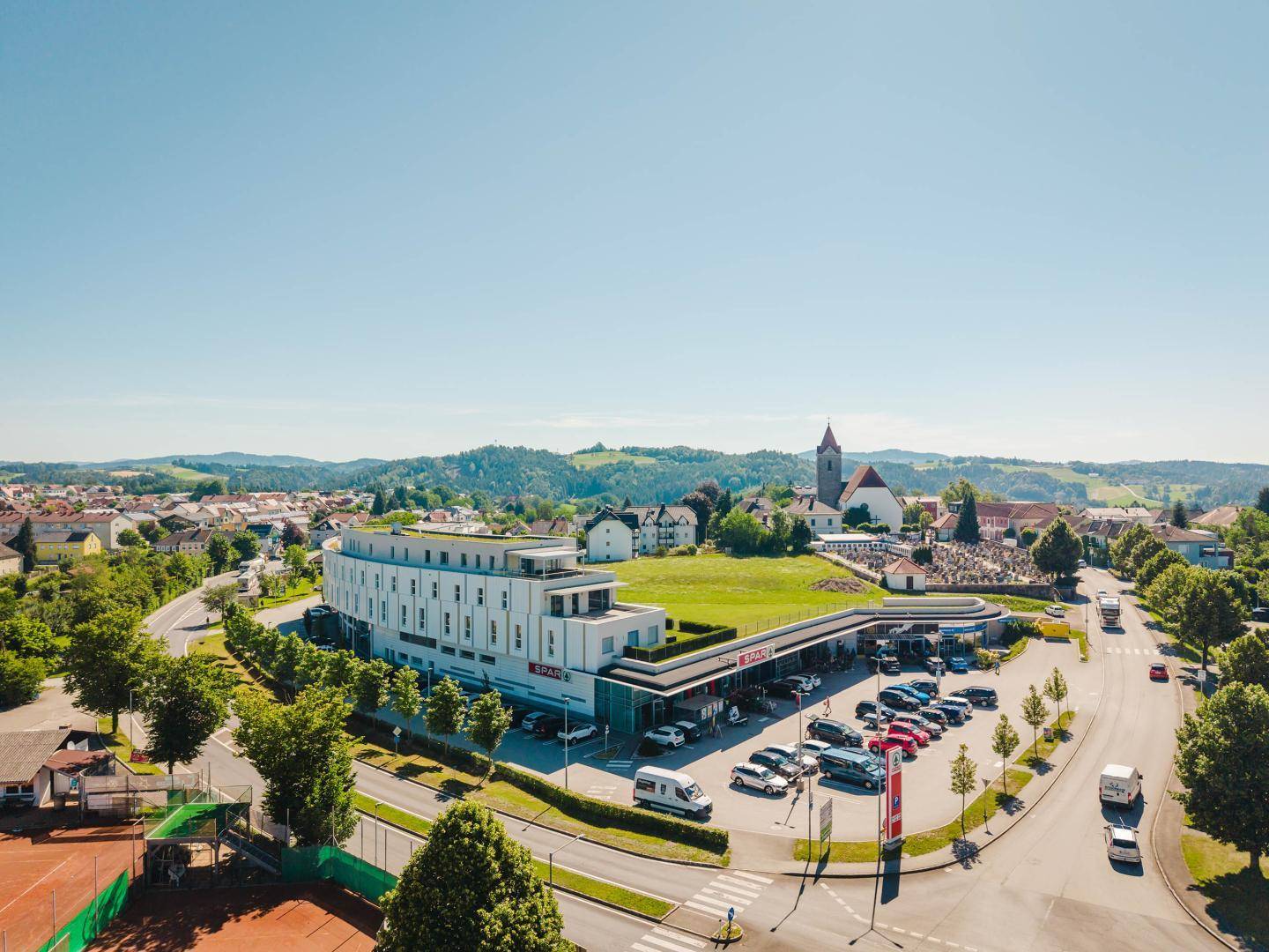 Panoramablick auf das moderne Gebäude, die Stadt und die weite grüne Landschaft.