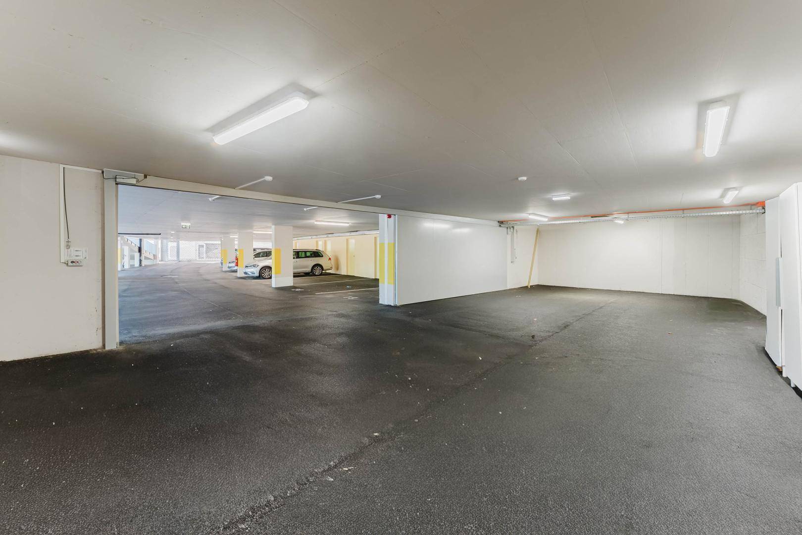 Geräumige Tiefgarage mit mehreren Stellplätzen und guter Beleuchtung.