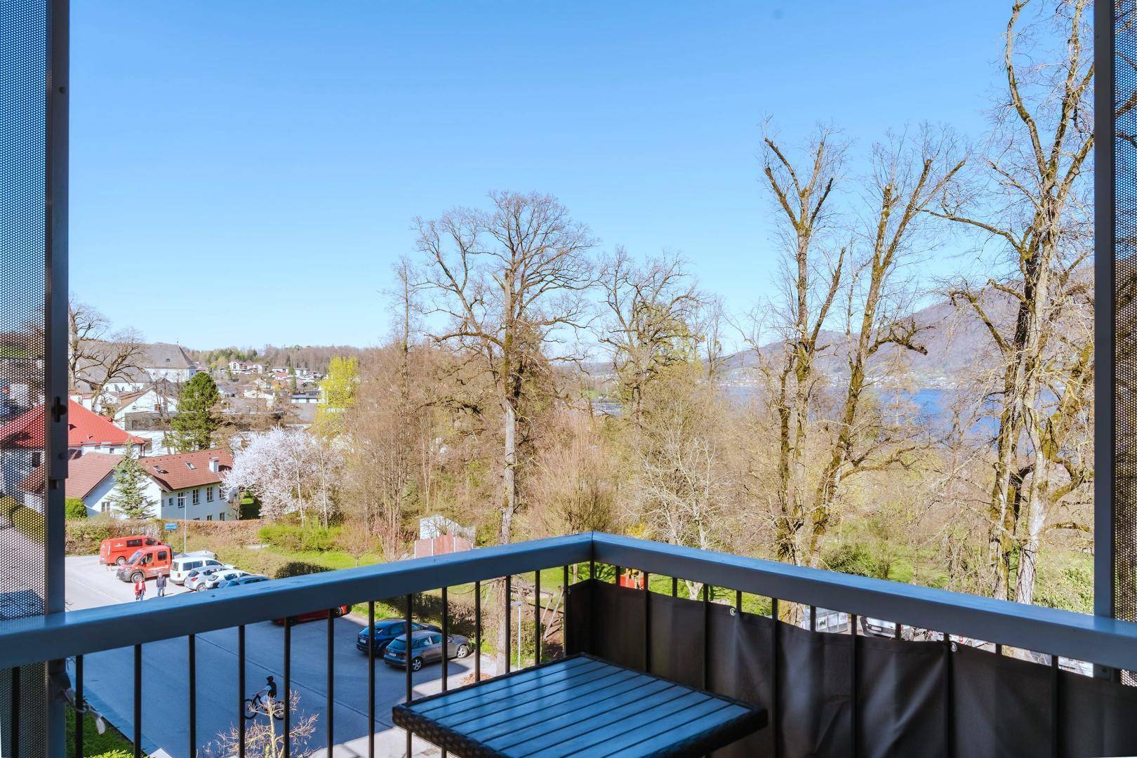 Heller Eckbalkon mit kleinem Tisch und Blick auf die Stadt und den See.