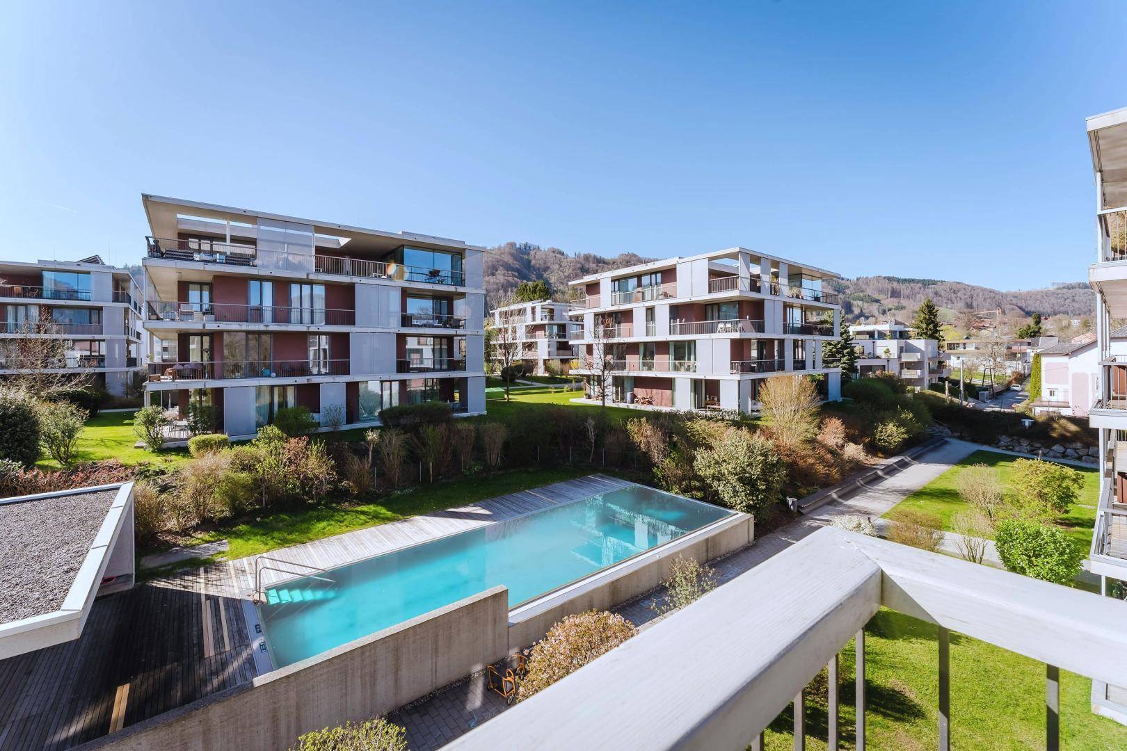 Geräumiger Balkon mit Blick auf den Gemeinschaftspool und die moderne Wohnanlage.