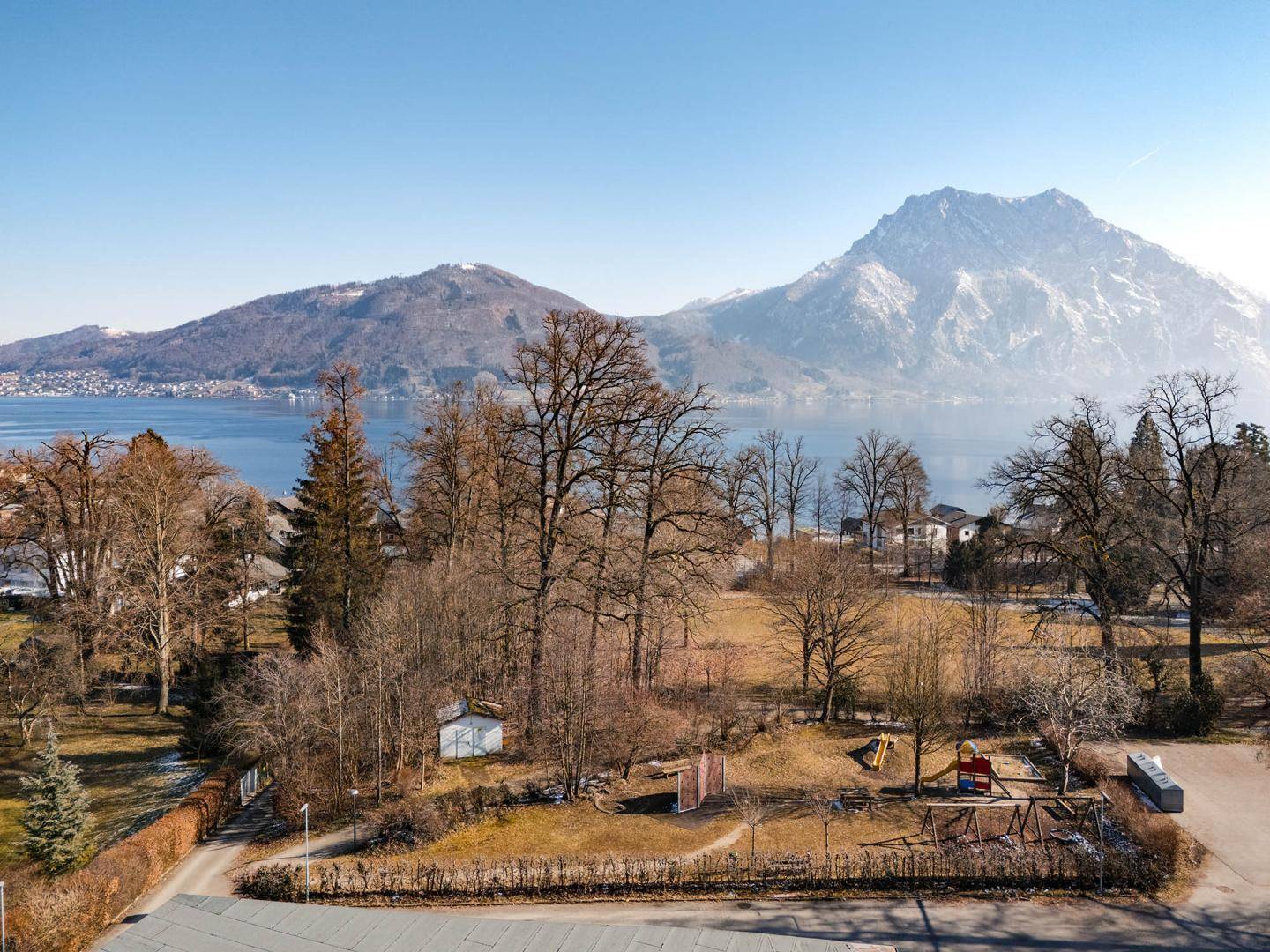 Weitläufige Parkanlage mit Spielplatz und beeindruckendem Blick auf See und Berge.