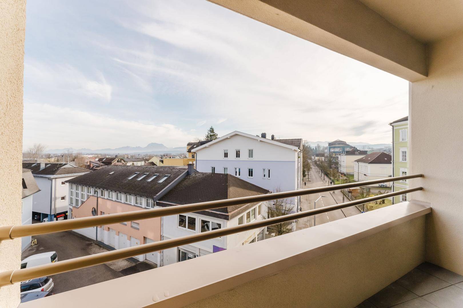 Blick vom Balkon auf die umliegende Stadtlandschaft und die fernen Berge.
