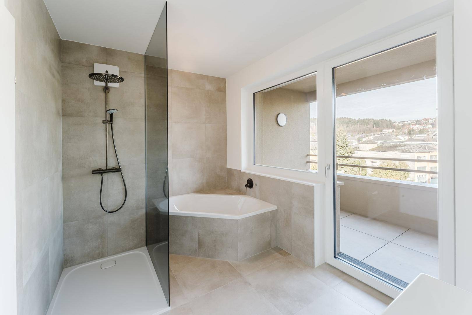 Modernes Badezimmer mit begehbarer Dusche, Badewanne und Zugang zu einem kleinen Balkon.