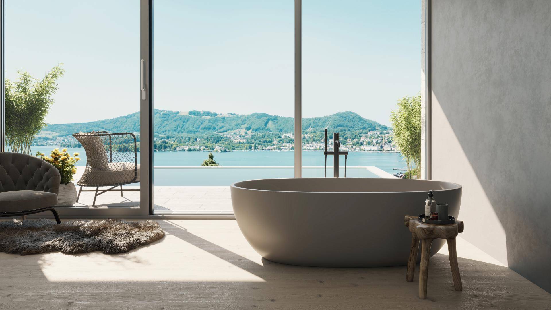 Luxuriöses Badezimmer mit freistehender Badewanne und Panoramablick auf den See.