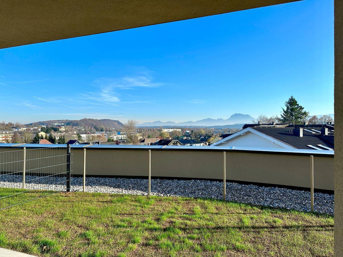 Weitläufiger Blick von der Gartenfläche über die umliegende Landschaft und ferne Berge.