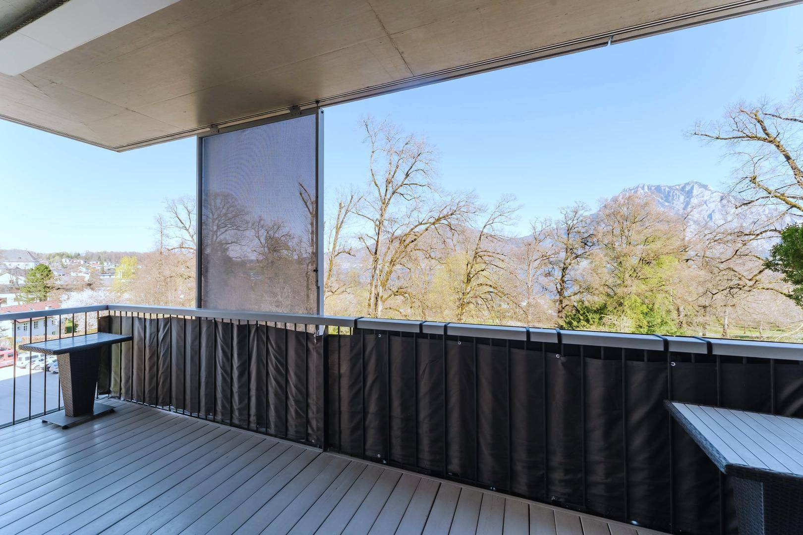 Geräumiger Balkon mit Sitzgelegenheiten und weitem Blick auf den See und die umliegende Landschaft.