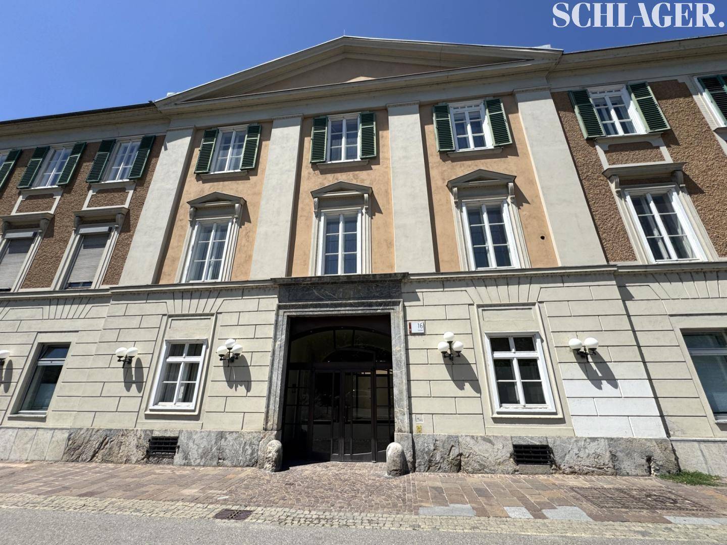 Detailansicht der historischen Fassade mit klassischem Eingangsbereich und symmetrischen Fenstern.
