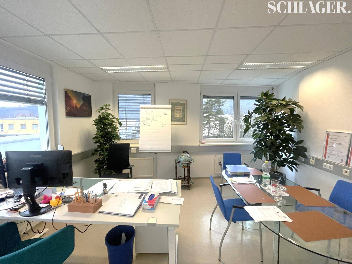 Geräumiges und helles Büro mit modernen Arbeitsplätzen, Besprechungstisch und Blick auf die Umgebung.