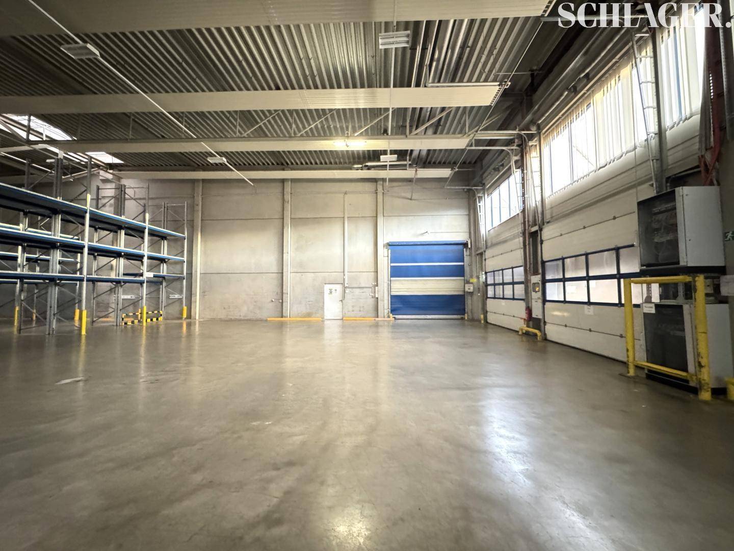 Große Lagerhalle mit Rolltoren und Laderampen, ideal für Logistik und Warenlagerung.