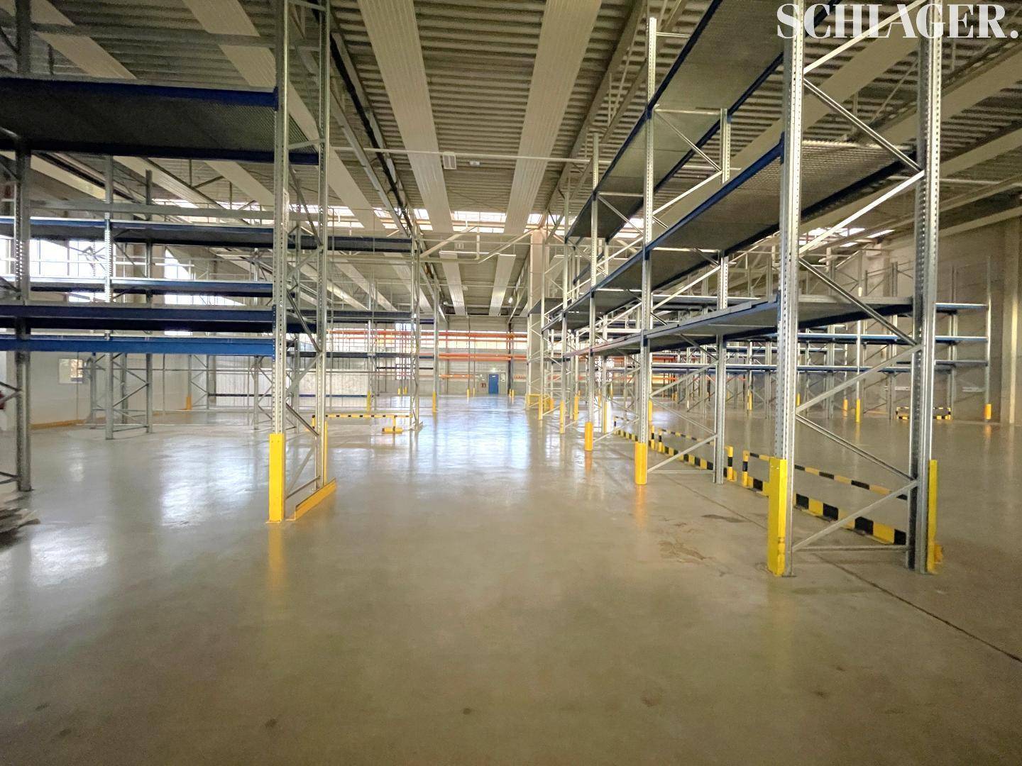 Moderne Lagerhalle mit robusten Metallregalen und Betonboden, bereit für industrielle Nutzung.
