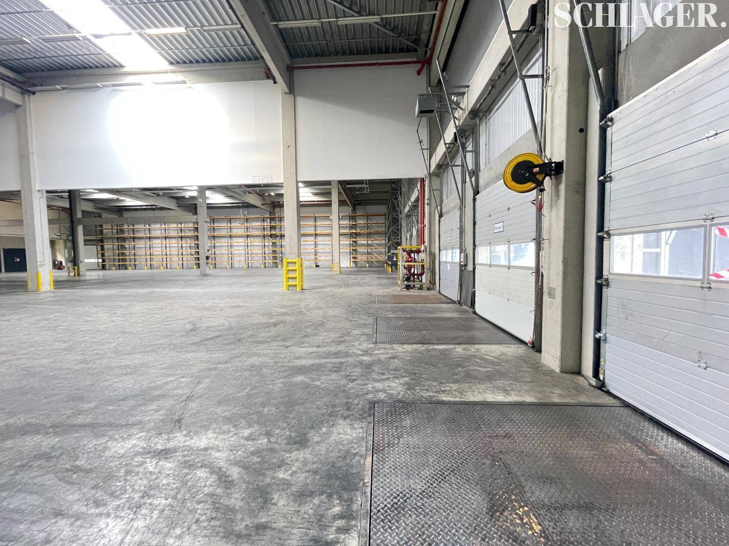 Ladebereich der Lagerhalle mit mehreren Rolltoren und Laderampen für effiziente Logistik.