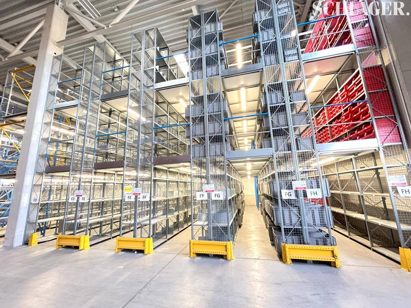 Hochregallager mit modernen, schmalen Metallregalsystemen für effiziente und dichte Lagerung.