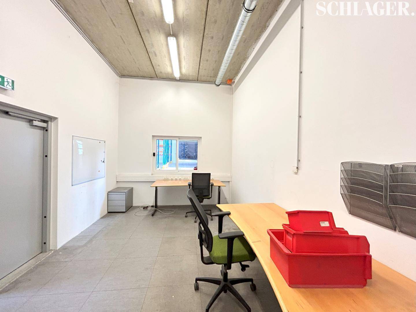 Funktionales Büro mit weißen Wänden, Betondecke, Fenster und zwei Arbeitsplätzen.