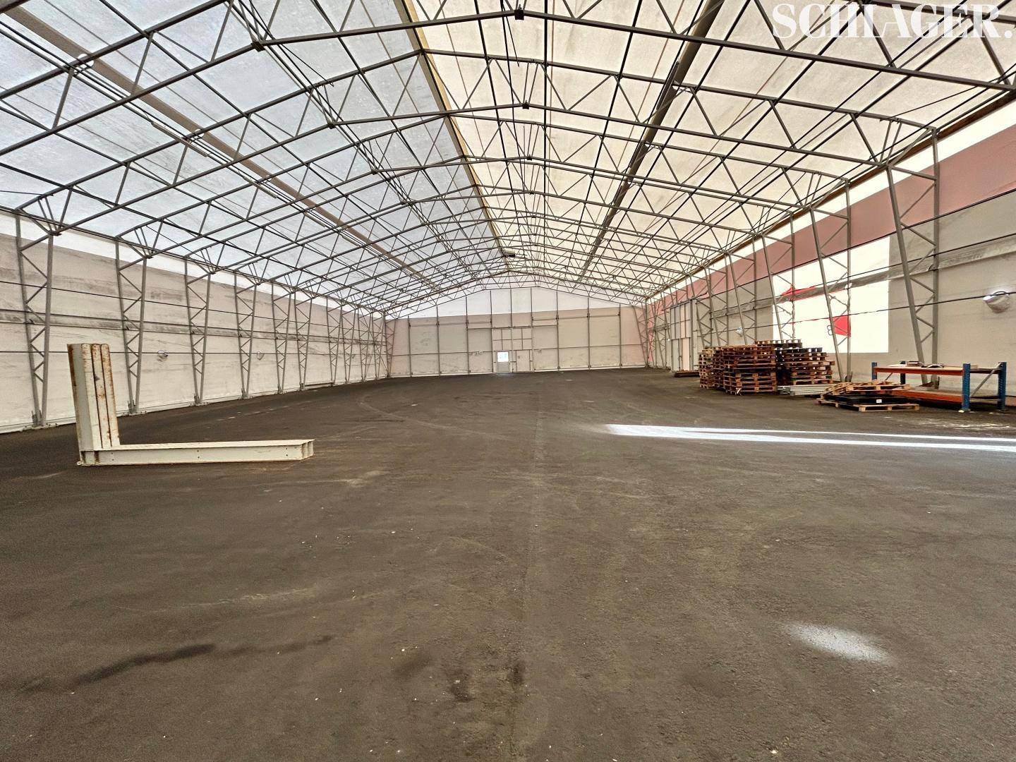 Große, helle Lagerhalle mit Leichtbaukonstruktion, Metallrahmen und vielseitig nutzbarer Freifläche.