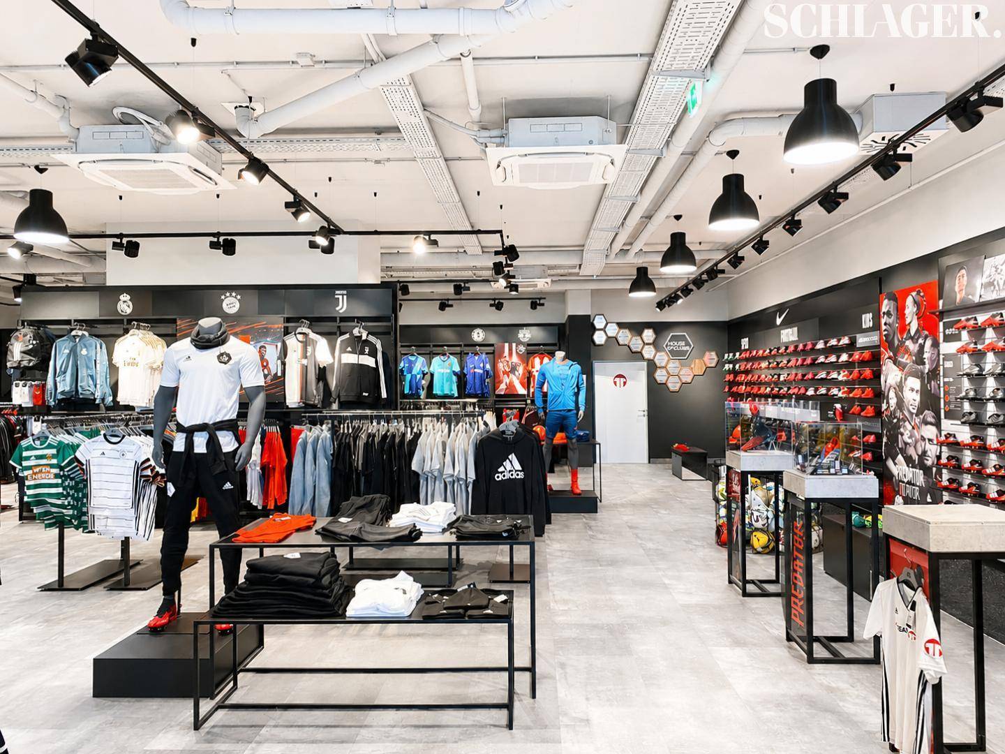 Moderner Sportartikel-Laden mit vielfältiger Produktpräsentation und industriellem Decken-Design.