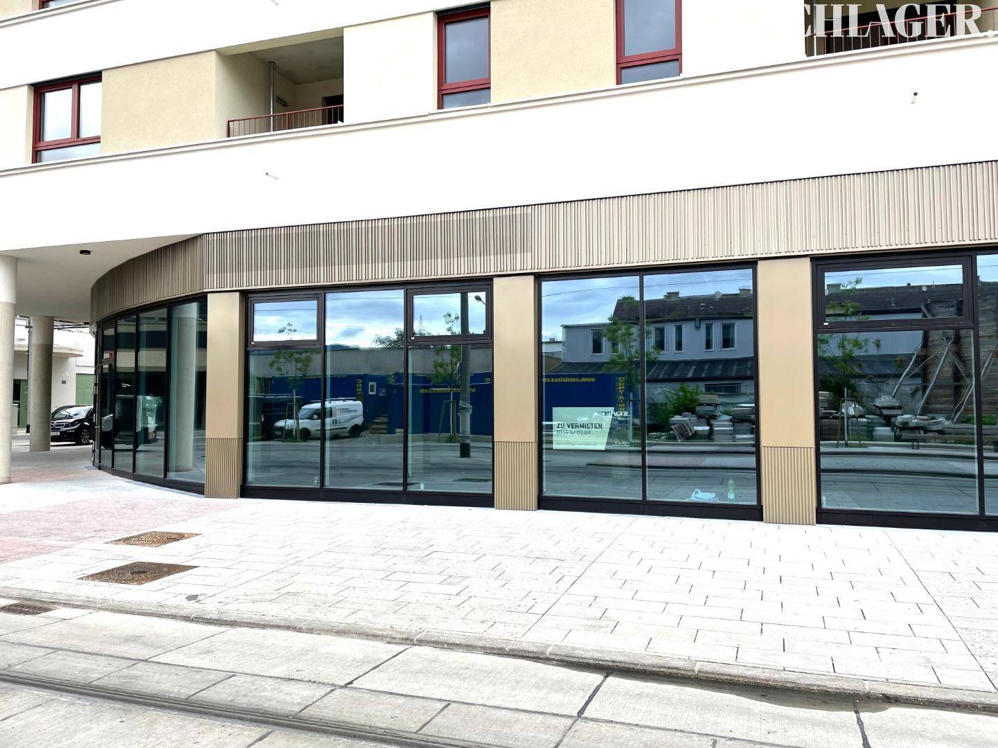Weitläufige Glasfassade eines modernen Geschäftsgebäudes im Erdgeschoss mit einem "Zu Vermieten"-Schild.